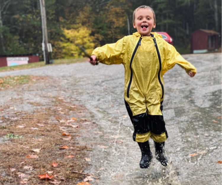 Boy enjoying being outside in the rain.