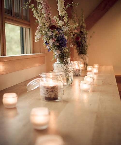a window bench with mason jars and tealights