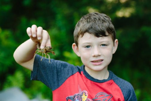 boy holding crawfish